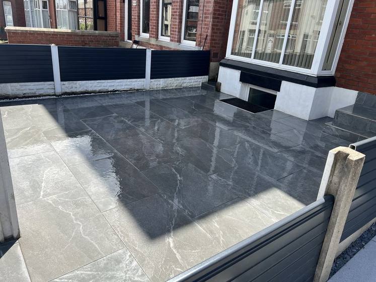 Grey porcelain patio slabs in a rear yard